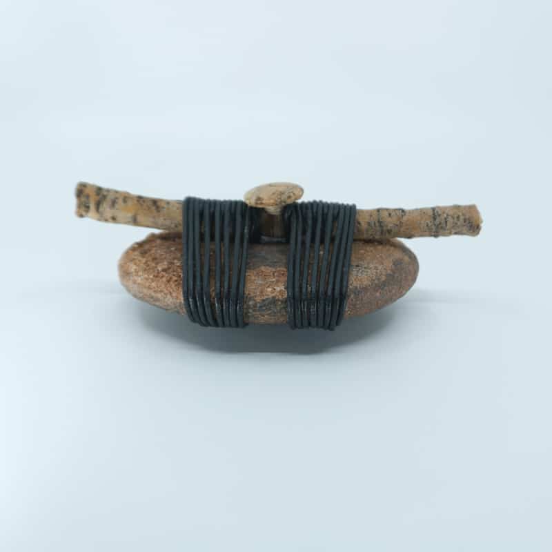 Side view of Entwined wrapped rock with stick and cork button