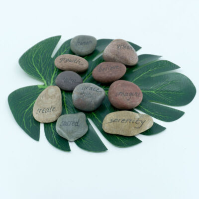 A mix of stones with words written on them like create, sacred, serenity, imagine, grace, growth, calm, believe, vision, honor